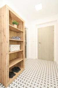 a room with a wooden cabinet with shoes on a tiled floor at Apartman Vita Lite in Trenčín