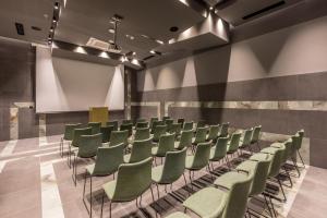 una sala conferenze con sedie verdi e schermo di Cora Hotel a Spalato (Split)