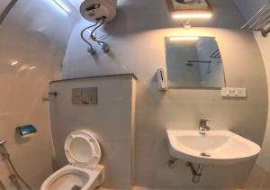 a small bathroom with a toilet and a sink at Hotel Prago by Green Deer Varanasi in Varanasi