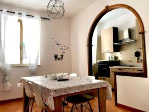 a kitchen with a table with chairs and a mirror at Jole Guesthouse in Mazzarino