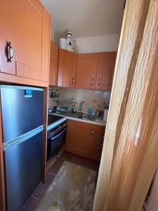 a kitchen with wooden cabinets and a blue refrigerator at Villa Maron - Platanitis Beach in Maronia