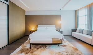 een slaapkamer met een groot bed en een bank bij Sheraton Xi'an South in Xi'an