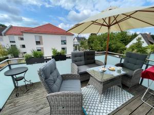 a patio with a table and chairs and an umbrella at Appartement Feucht -Bhf 5 Min - Nähe Messe in Feucht