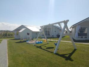 a swing set in a yard next to houses at Zante Sarbinowo in Sarbinowo