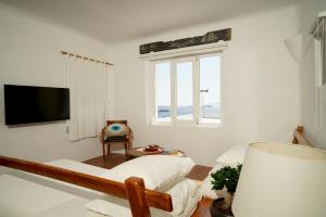 um quarto branco com uma cama e uma janela em Serenity - Traditional house with stunning sea view em Tagou