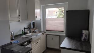 una pequeña cocina con fregadero y ventana en Wohnung Meeresbrise 48 qm mit Balkon en Rostock