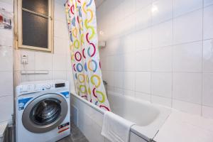 a washing machine in a bathroom next to a tub at Vltava Apartments Prague 7 in Prague