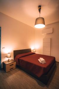1 dormitorio con 1 cama con colcha roja en CASA LUCIA , ricarica auto elettrica GRATUITA en Siniscola