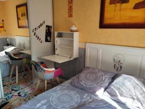 a bedroom with a bed and a desk and chairs at La Palatine chambre chez l habitant à 20 mn de Rodez in Calmont