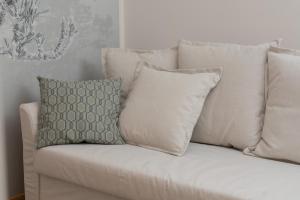 a white couch with two pillows on it at Bright & Stylish Apartment with Balcony 1,5 km to Gdańsk Main City by Renters in Gdańsk