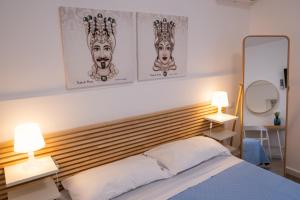 Matilde’s Holiday House في تيراسيني: غرفة نوم بها سرير مع مصباحين