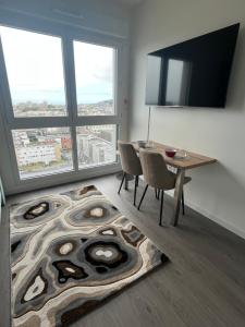 a dining room with a table and a large window at Vivez le panorama à 180 - PARKING - Proximité de la gare in Le Havre