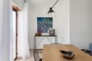 une salle à manger avec une table en bois et un tableau dans l'établissement JOIVY Sunny apartment in Marvila, à Lisbonne