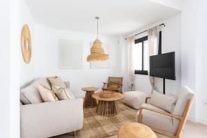 uma sala de estar com um sofá e uma televisão em Esencia Marbella Casas Boutique em Estepona