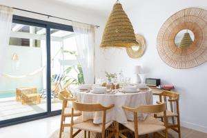 une salle à manger avec une table et des chaises blanches dans l'établissement Esencia Marbella Casas Boutique, à Estepona