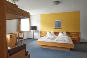 a hotel room with a bed and a desk at Tafelspitz Gruppenhaus Arlberg in Wald am Arlberg