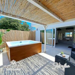 a hot tub in a patio with a wooden ceiling at Giardino D'Oriente in Otranto