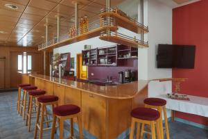 a bar with wooden stools and a counter top at Tafelspitz Gruppenhaus Arlberg in Wald am Arlberg