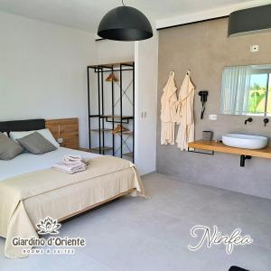 a bedroom with a bed and a sink and a tub at Giardino D'Oriente in Otranto