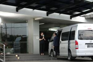 Ein Mann und eine Frau stehen neben einem weißen Van. in der Unterkunft Amaris Hotel Bandara Soekarno Hatta in Tangerang