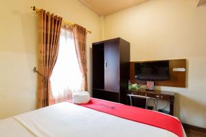 a hotel room with a bed and a television at RedDoorz near Halim Perdanakusuma 3 in Jakarta