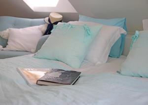 a book sitting on top of a bed with pillows at Lavender Village in Kiemeliai