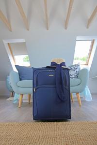 a blue suitcase sitting on the floor in a living room at Lavender Village in Kiemeliai
