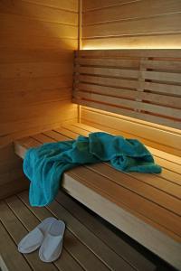 Una cama en una sauna con una manta azul y zapatos en Lavender Village en Kiemeliai