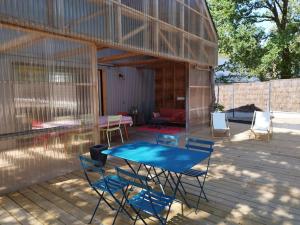een patio met een tafel en stoelen voor een gebouw bij Le charme du bois - 8 à 10 personnes- Maison entière in La Turballe