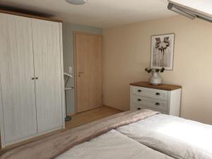 1 dormitorio con cama blanca y vestidor en Moderne DG-Wohnung in Mainleus, en Mainleus