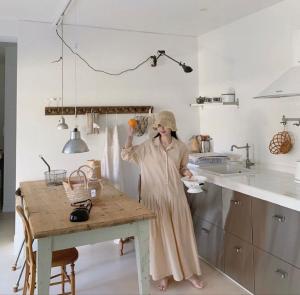 a woman standing in a kitchen with a table at Maison de Clare 메종드클레어 in Gyeongju