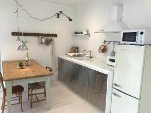 a kitchen with a table and a white refrigerator at Maison de Clare 메종드클레어 in Gyeongju +25 photos