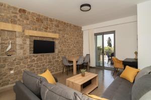 LITHOS SUITES في فينيكونتا: غرفة معيشة مع أريكة وجدار من الطوب
