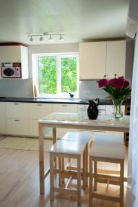 uma cozinha com uma mesa com um vaso de flores em Lavender House em Kuressaare