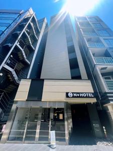 un edificio con un cartello hotel di fronte di Nplus HOTEL Higashikanda-akihabara a Tokyo