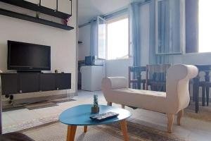 a living room with a tv and a chair and a table at Calm & New_Epinay-Le Bourget in Épinay-sur-Seine