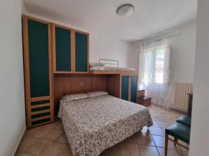 ein Schlafzimmer mit einem Bett, einem Schrank und einem Fenster in der Unterkunft A 2 passi dal blu in Roseto degli Abruzzi