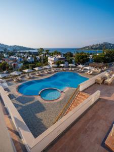 a swimming pool with lounge chairs and a resort at Elementa Boutique Hotel - Adults Only in Yalıkavak