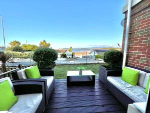 een patio met banken en een tafel op een terras bij Apartment 3 Benllech with Sea views in Benllech