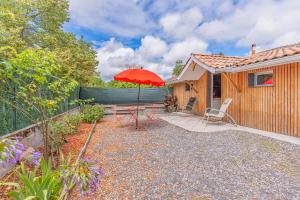 a patio with a red umbrella and a house at Studio Bassin d'arcachon in La Teste-de-Buch