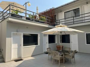 a patio with a table with an umbrella and chairs at Casas de Luanda GH-Alvalade in Luanda