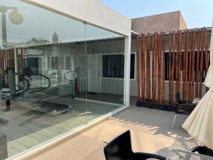 a balcony with glass doors and chairs on a patio at Casas de Luanda GH-Alvalade in Luanda +4 photos