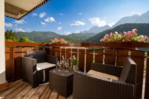 a balcony with chairs and a table with wine glasses at Residence Panorama in Val di Zoldo