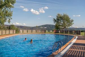 zwei Personen schwimmen in einem Pool in der Unterkunft Parador de Verín in Monterrei