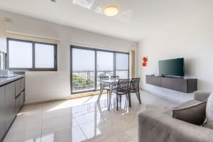 uma cozinha e sala de estar com mesa e cadeiras em New top floor apartment enjoy opening views em San Ġwann