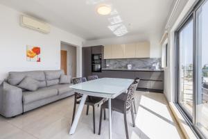uma sala de estar com uma mesa e um sofá em New top floor apartment enjoy opening views em San Ġwann