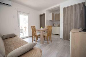 a bedroom with a table and chairs and a kitchen at Apartment Miske in Ivanica