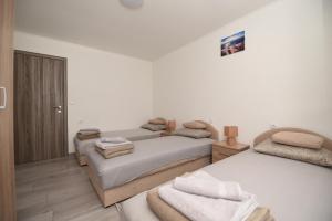 a bedroom with two beds with towels on them at Apartment Miske in Ivanica