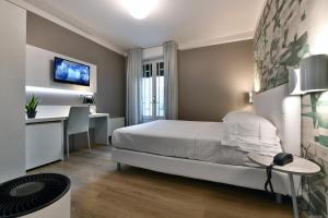 um quarto de hotel com uma cama, uma secretária e uma mesa em Hotel Residence Esplanade em Viareggio