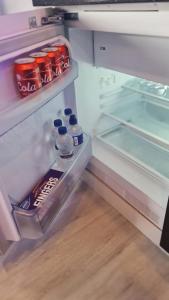 an open refrigerator with bottles of soda and drinks at #6 TGHA Luxury Two Bedroom Apartment in Athlone in Athlone